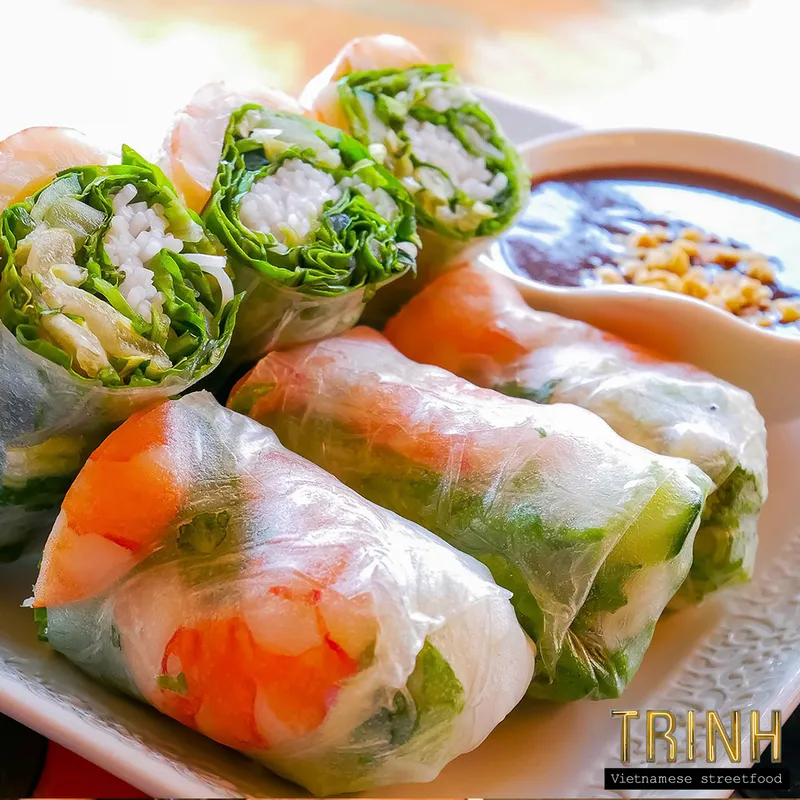 Verse gỏi cuốn — rijstpapierrolletjes met garnaal en kruiden — met een bakje pindasaus.