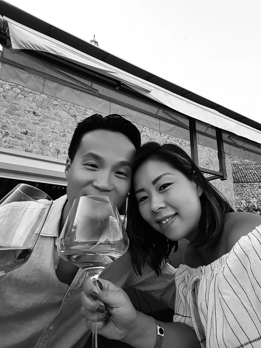 Tanja Trinh-Man en Michael Man proosten met wijnglazen, in zwart-wit
