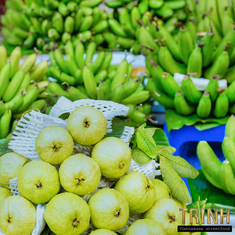Stapels groene bananen en guaves op een Vietnamese markt.