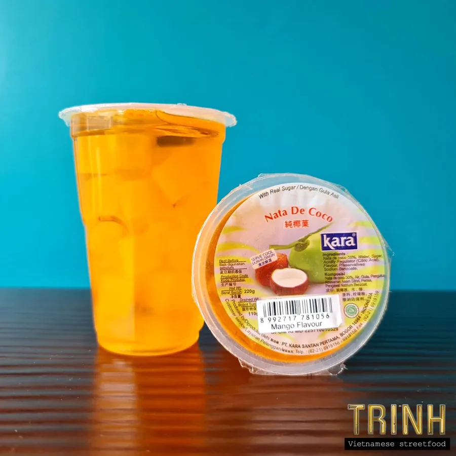 Beker ijsthee naast een kuipje nata de coco met mangosmaak.